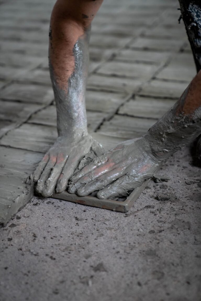 Artisan pressing clay into a square mold to make handmade zellige tiles