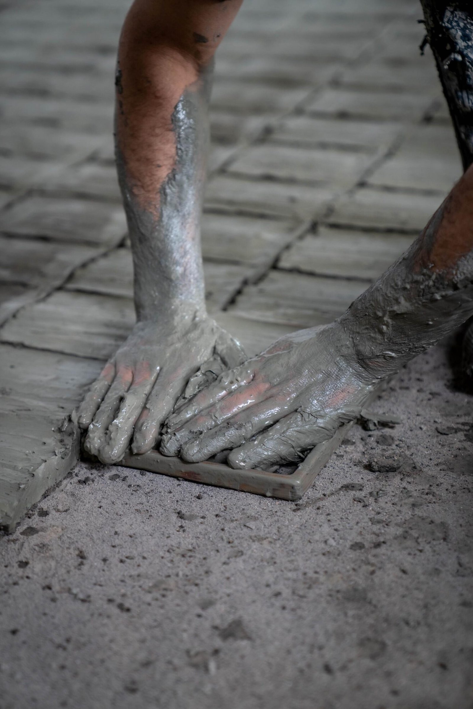 Artisan pressing clay into a square mold to make handmade zellige tiles