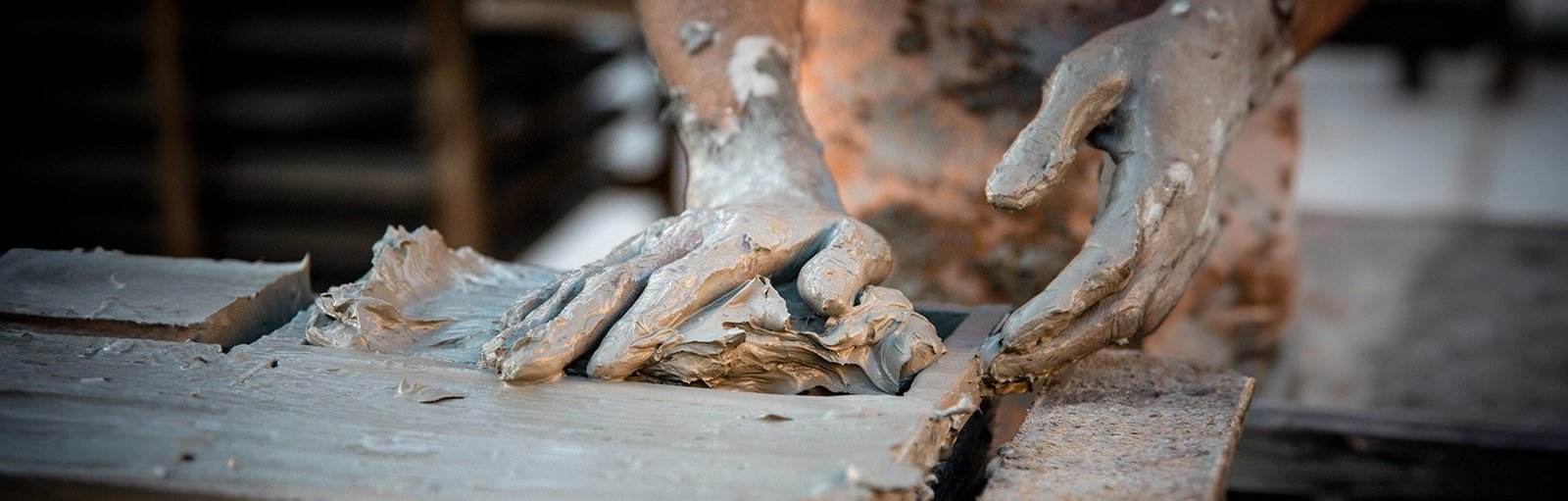 Artisan pressing wet clay into a mold to make zellige tiles